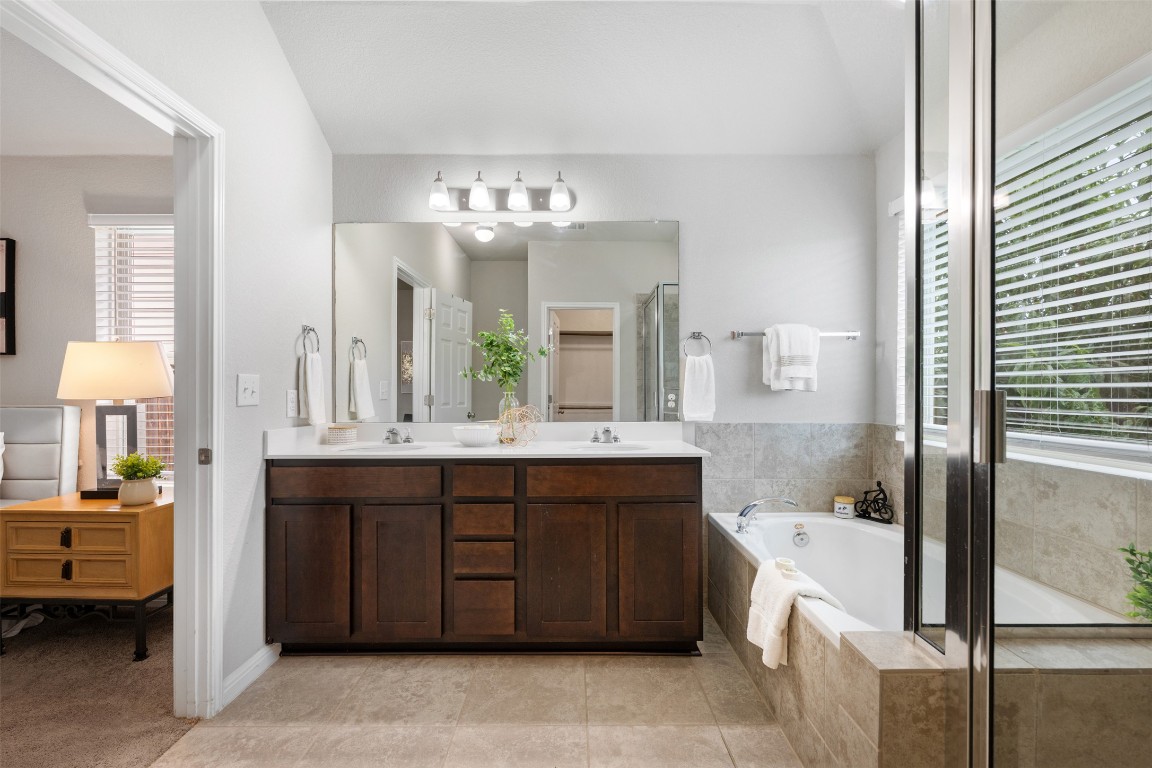 433 Rusk Bluff Avenue Leander, TX 78641 - Photo 12 of 22 Bathroom featuring double vanity, a bath, and a shower stall