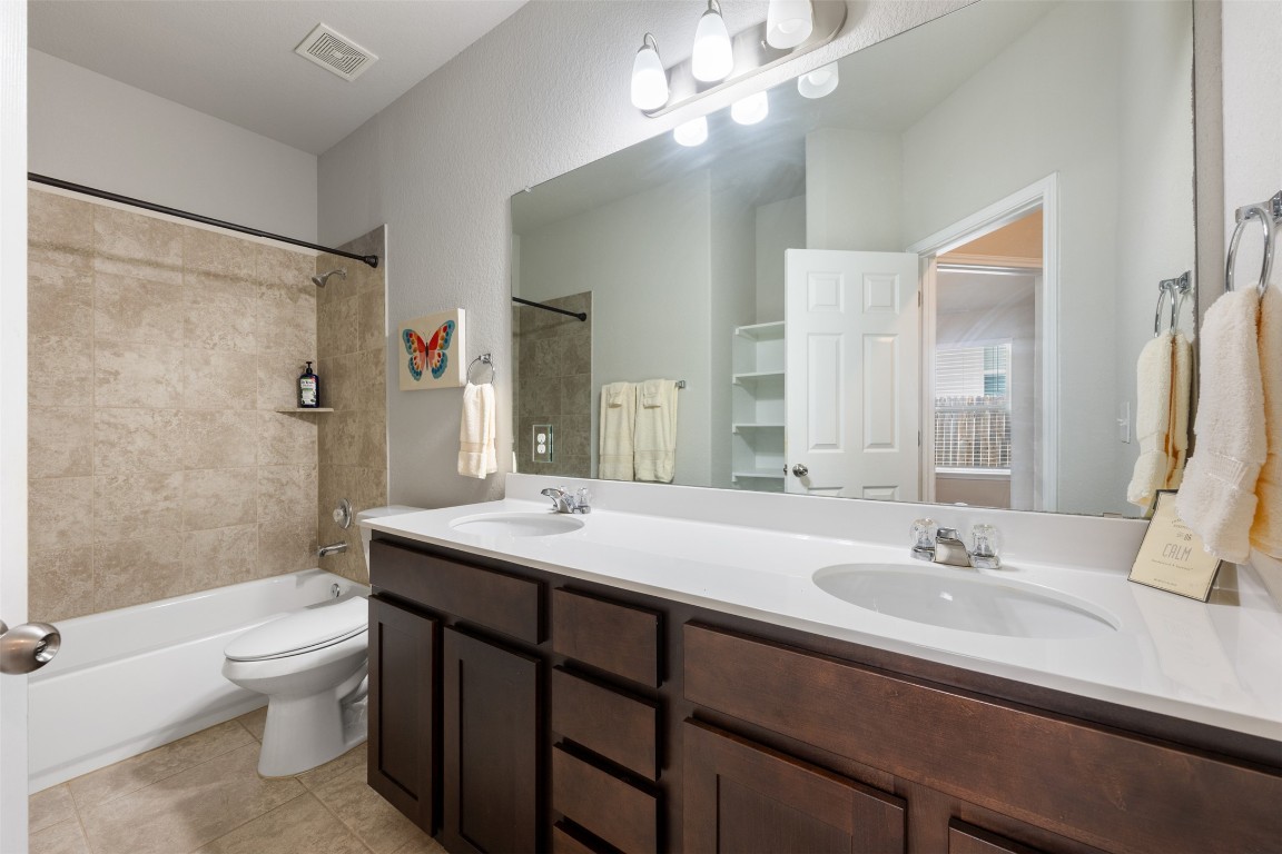 433 Rusk Bluff Avenue Leander, TX 78641 - Photo 15 of 22 Bathroom featuring shower / bathtub combination, double vanity, and tile patterned flooring