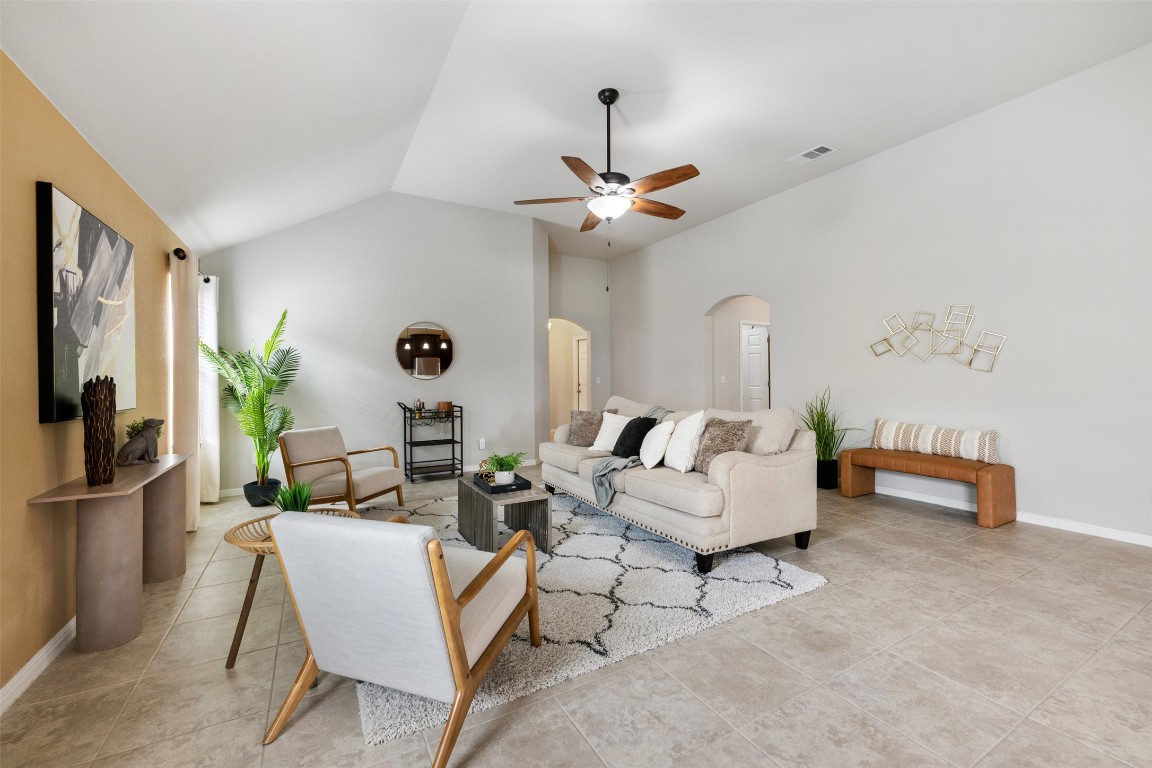 433 Rusk Bluff Avenue Leander, TX 78641 - Photo 4 of 22 Living room with arched walkways, a ceiling fan, lofted ceiling, and light tile patterned flooring