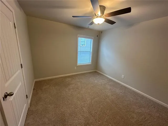 an empty room with windows and ceiling fan view