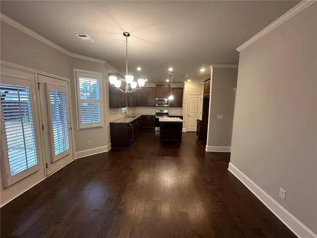 an open kitchen with wooden floor and a chandelier