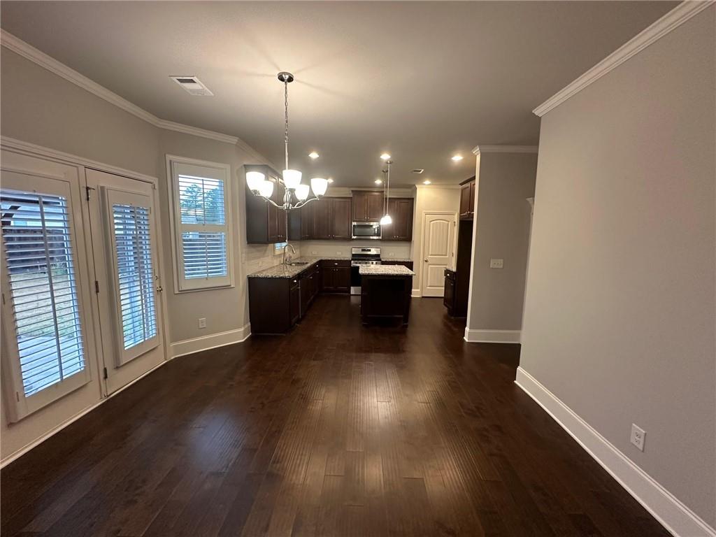 623 Little Bear Loop Canton, GA 30114 - Photo 3 of 24 an open kitchen with wooden floor and a chandelier