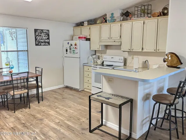 a kitchen with stainless steel appliances granite countertop a stove a sink dishwasher and a refrigerator with wooden cabinets