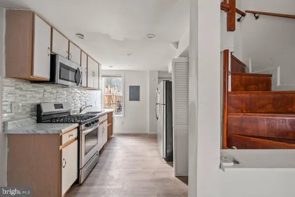 a kitchen with stainless steel appliances granite countertop a refrigerator and a stove