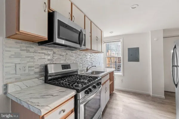 a kitchen with stainless steel appliances white cabinets and a sink