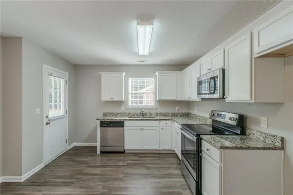 a kitchen with granite countertop a sink and cabinets
