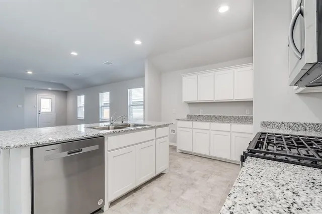 a kitchen with sink stove and cabinets