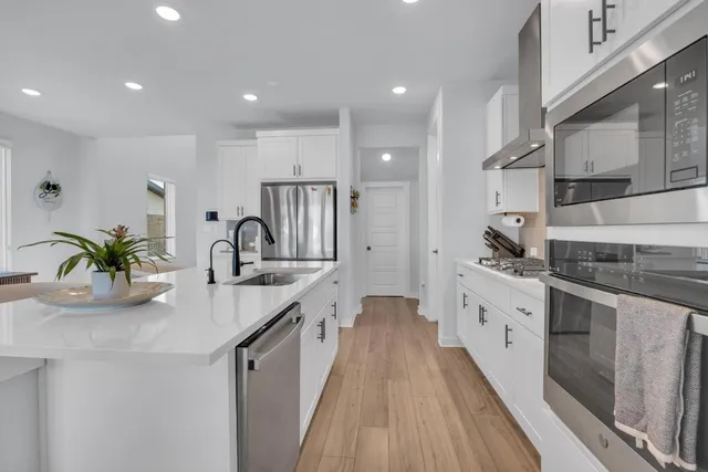 a kitchen with sink a stove and cabinets