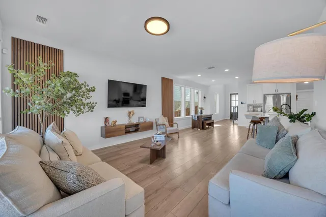 a living room with furniture and a wooden floor