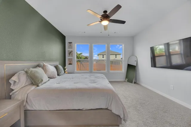 a bed room with a bed and a ceiling fan