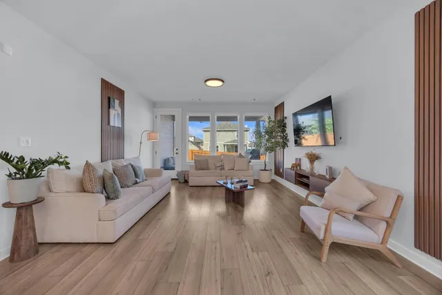 a kitchen with stainless steel appliances granite countertop a stove a sink a refrigerator and white cabinets with wooden floor