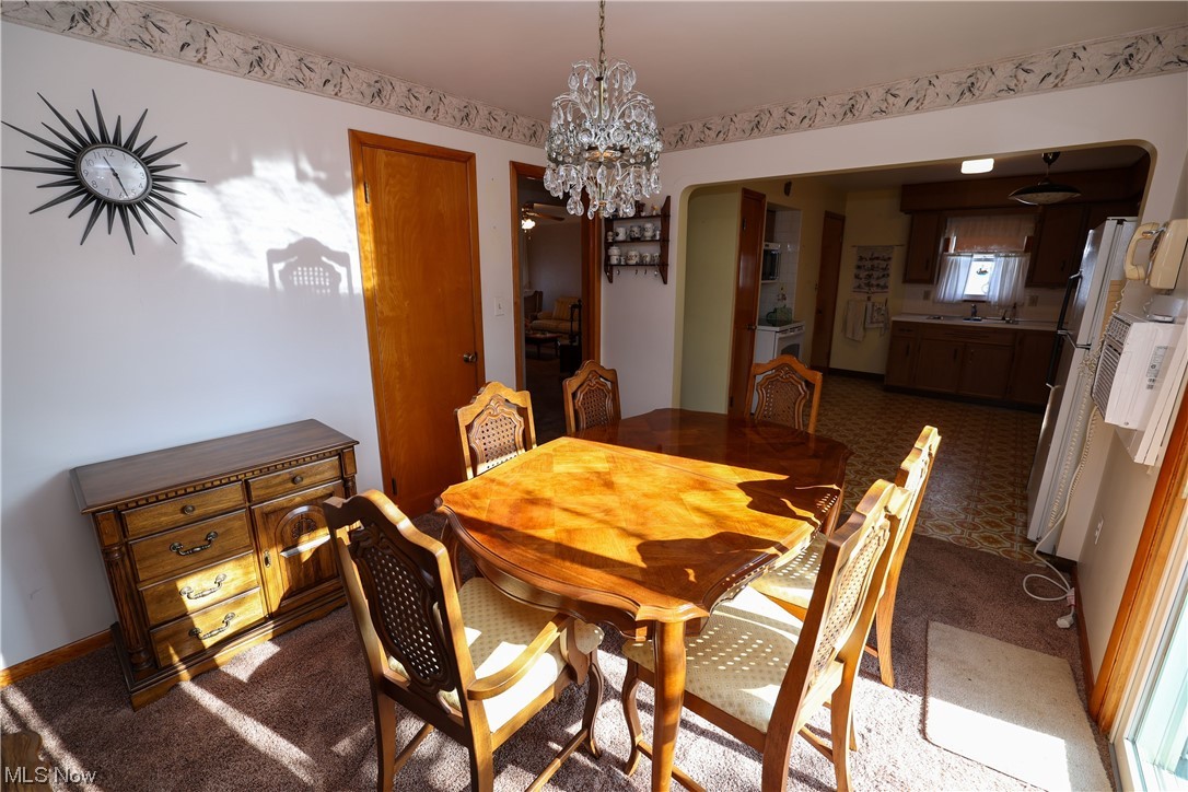 29252 Barjode Road Willowick, OH 44095 - Photo 9 of 21 Dining area featuring an inviting chandelier and dark colored carpet