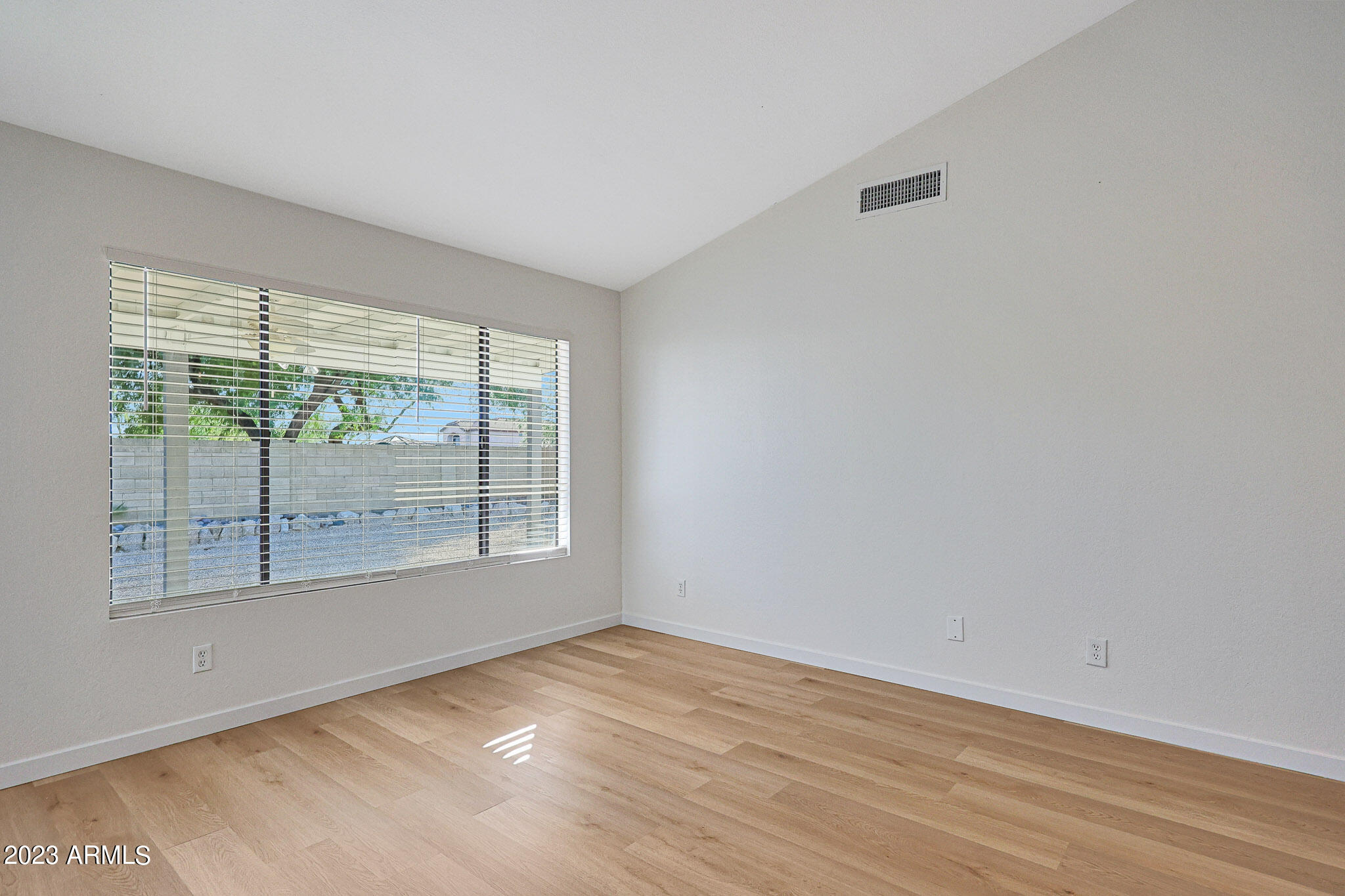 613 West Rosemonte Drive Phoenix, AZ 85027 - Photo 17 of 24 a view of an empty room with wooden floor and a window