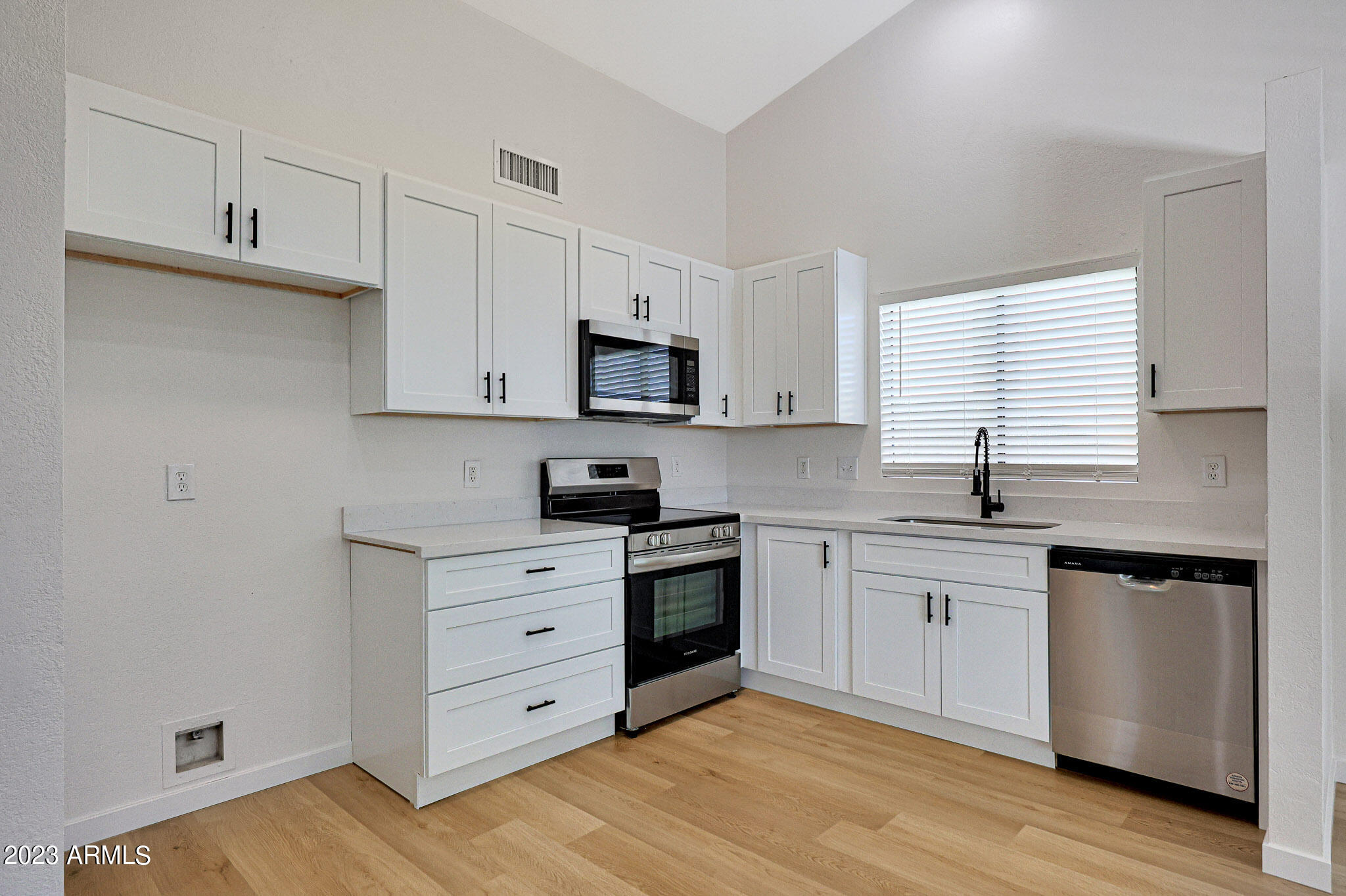 613 West Rosemonte Drive Phoenix, AZ 85027 - Photo 19 of 24 a kitchen with granite countertop white cabinets and white appliances