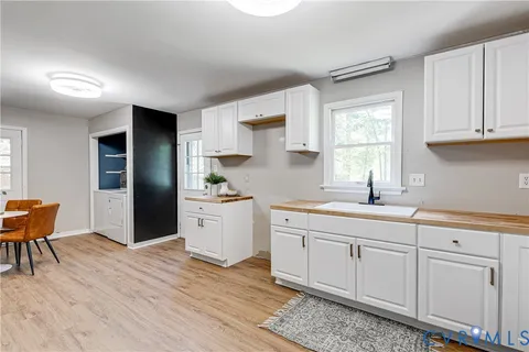 a kitchen with white cabinets and sink