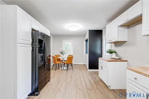 a kitchen with stainless steel appliances granite countertop furniture wooden floor and a refrigerator