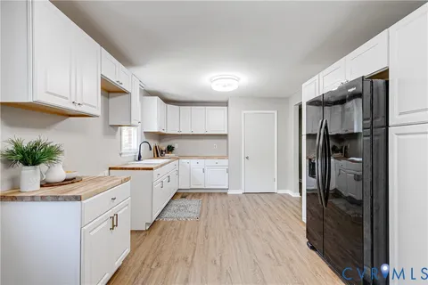 a kitchen with white cabinets and appliances