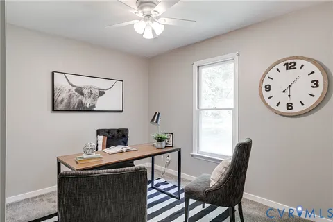 a view of a workspace with furniture and a window