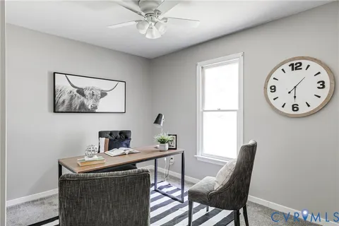 a view of a workspace with furniture and a window