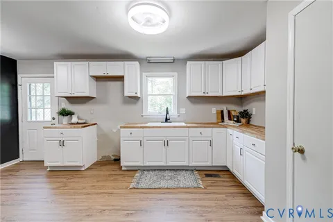 a kitchen with granite countertop white cabinets white stainless steel appliances with a sink and dishwasher