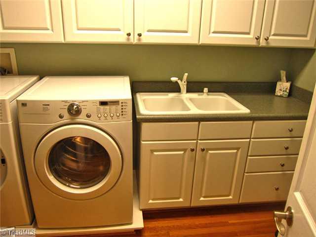 6330 Rustinburg Road Clemmons, NC 27012 - Photo 14 of 16 Laundry Room. Laundry room off of kitchen features built-in sink, built-in ironing board, and plenty of shelving and storage.
