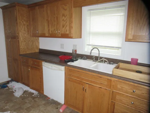 a kitchen with a sink cabinets and a window