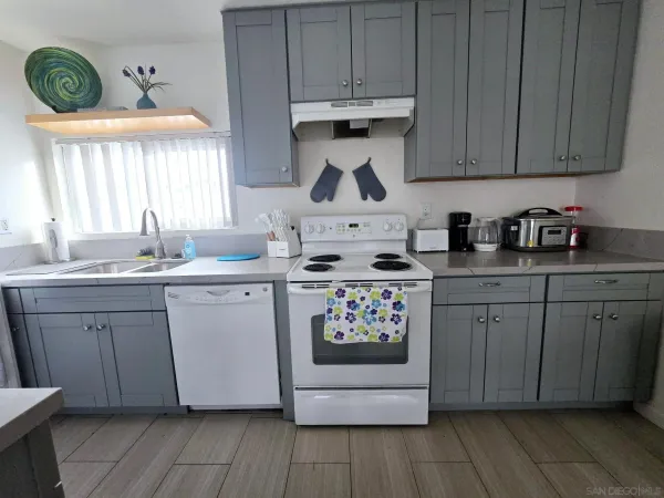 a kitchen with stainless steel appliances white cabinets a stove a sink and a refrigerator