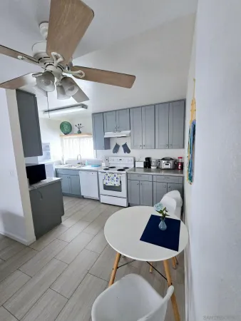 a kitchen with a dining table chairs stainless steel appliances and cabinets