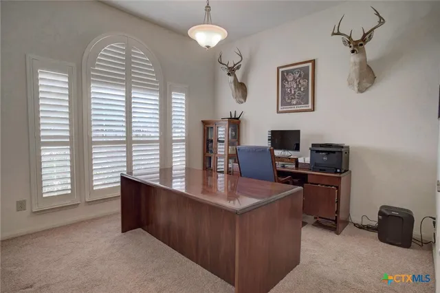 a view of a workspace with furniture and a window