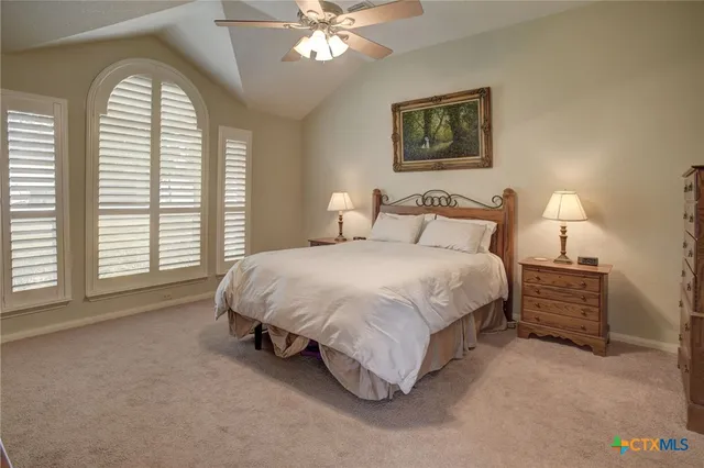 a spacious bedroom with a bed a window and a chandelier