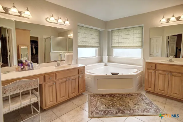a spacious bathroom with a tub sink and mirror