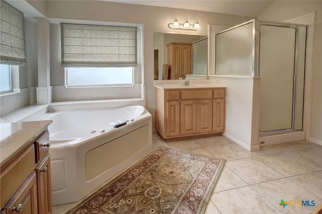 a bathroom with a tub sink and mirror
