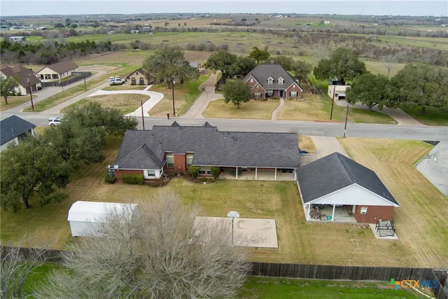 an aerial view of residential houses with outdoor space and lake view