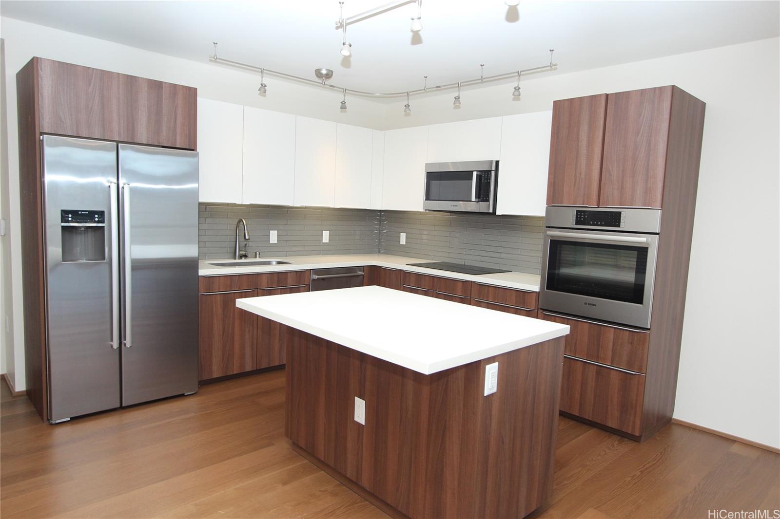a kitchen with kitchen island a counter top space cabinets and stainless steel appliances