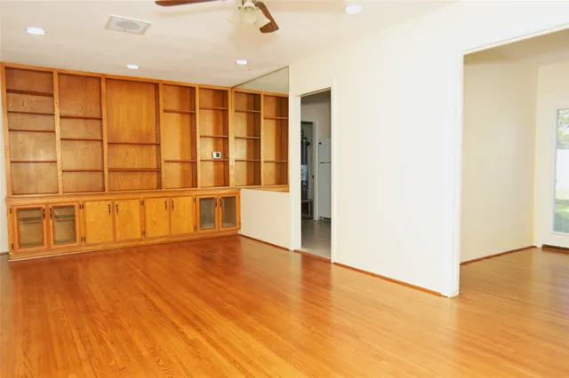 a view of an empty room with wooden floor