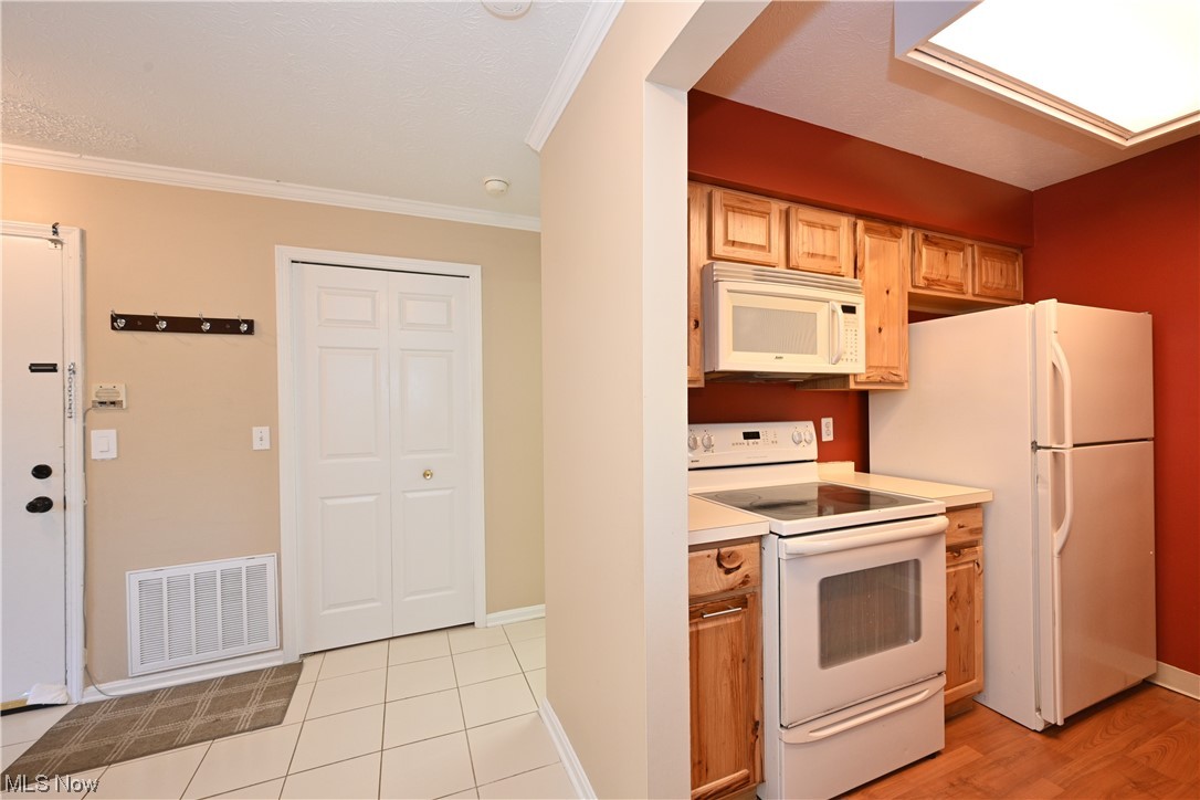 28140 Detroit Road, Unit A1 Westlake, OH 44145 - Photo 6 of 30 Kitchen with white appliances, light hardwood flooring, and ornamental molding