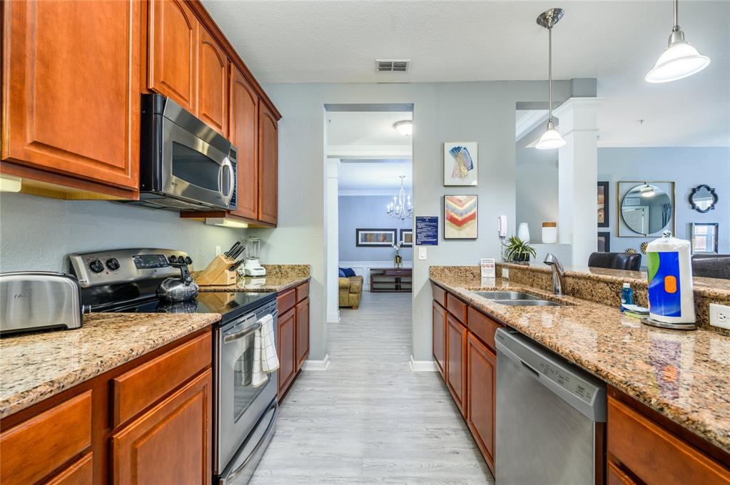 5012 Shoreway Loop, Unit 20507 Orlando, FL 32819 - Photo 14 of 49 a kitchen with stainless steel appliances granite countertop a sink stove and cabinets