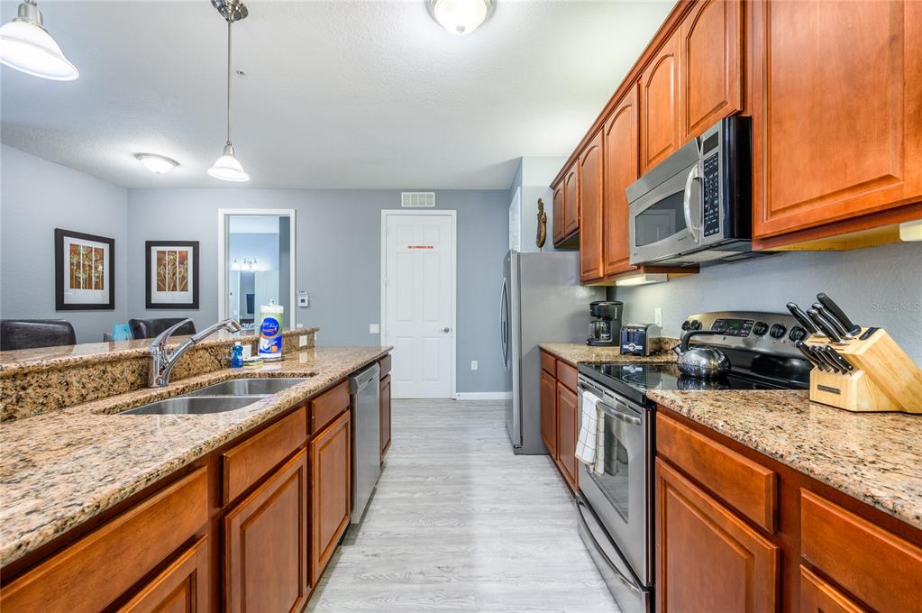 5012 Shoreway Loop, Unit 20507 Orlando, FL 32819 - Photo 15 of 49 a kitchen with stainless steel appliances granite countertop a sink a stove and a wooden floors