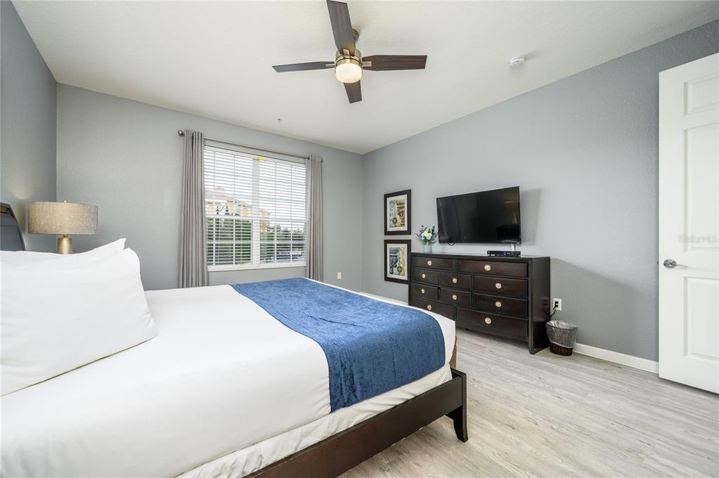 5012 Shoreway Loop, Unit 20507 Orlando, FL 32819 - Photo 19 of 49 a bedroom with a bed and a flat tv screen on dresser