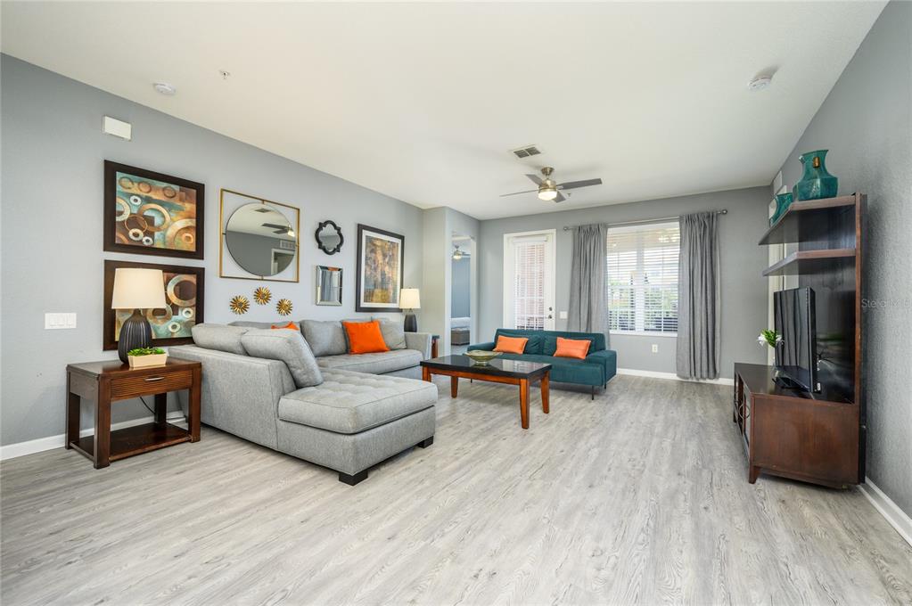 5012 Shoreway Loop, Unit 20507 Orlando, FL 32819 - Photo 5 of 49 a living room with furniture and a wooden floor