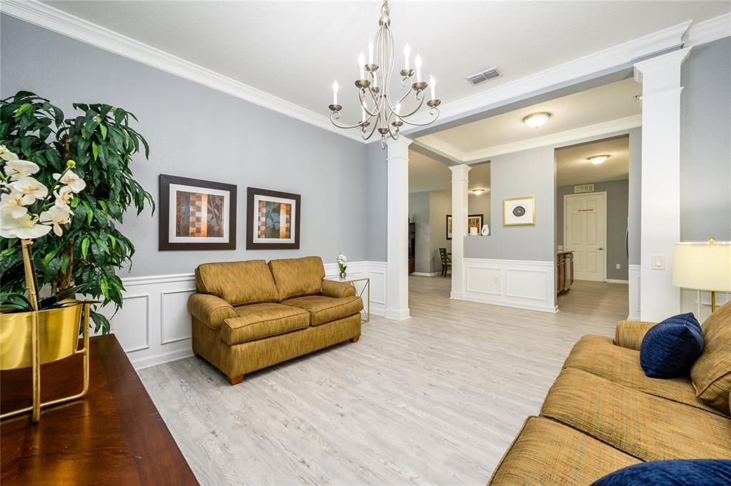 5012 Shoreway Loop, Unit 20507 Orlando, FL 32819 - Photo 8 of 49 a living room with furniture and a chandelier