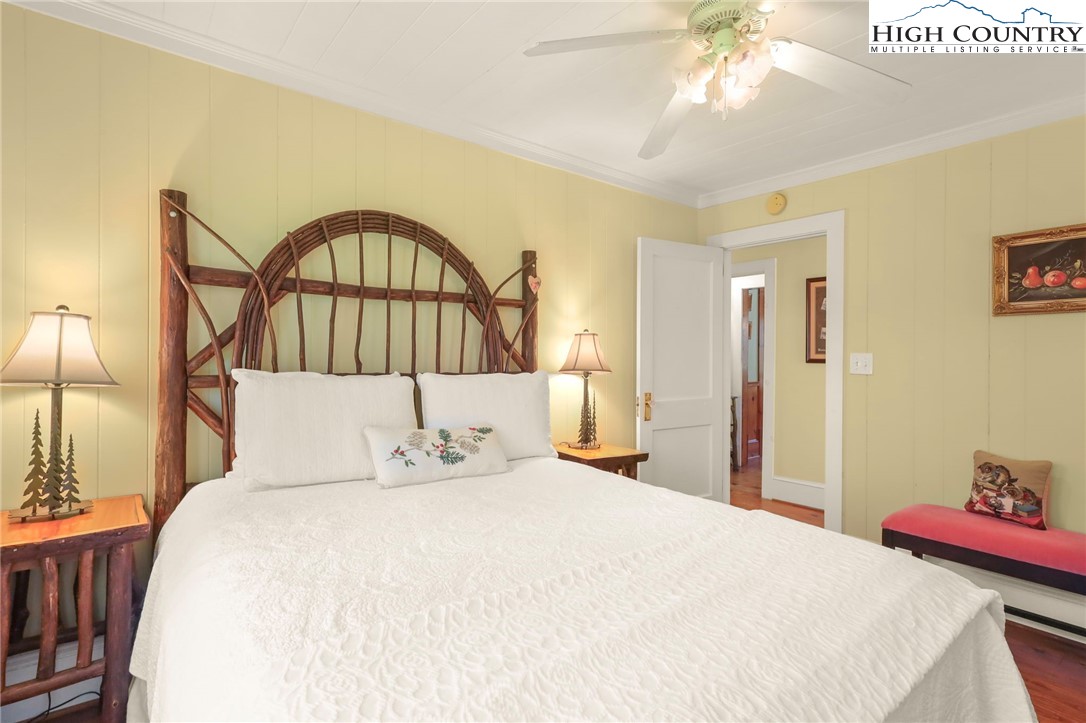 326 Ransom Street Blowing Rock, NC 28605 - Photo 17 of 25 a bedroom with a bed and a chandelier