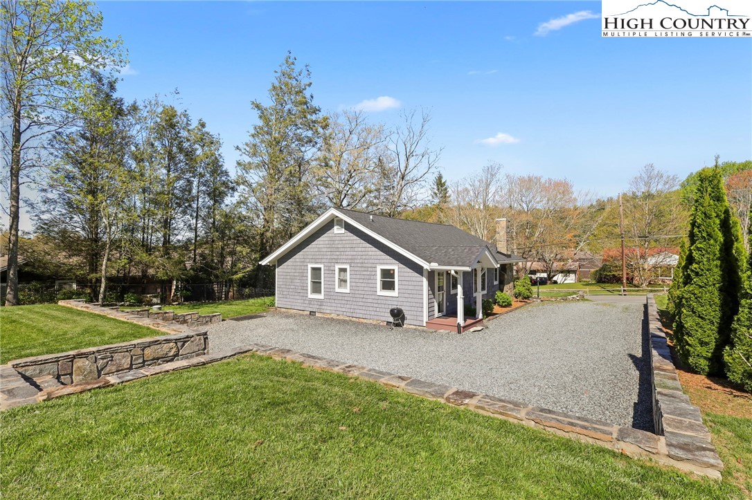 326 Ransom Street Blowing Rock, NC 28605 - Photo 25 of 25 a view of a house with a yard and table and chairs under an umbrella