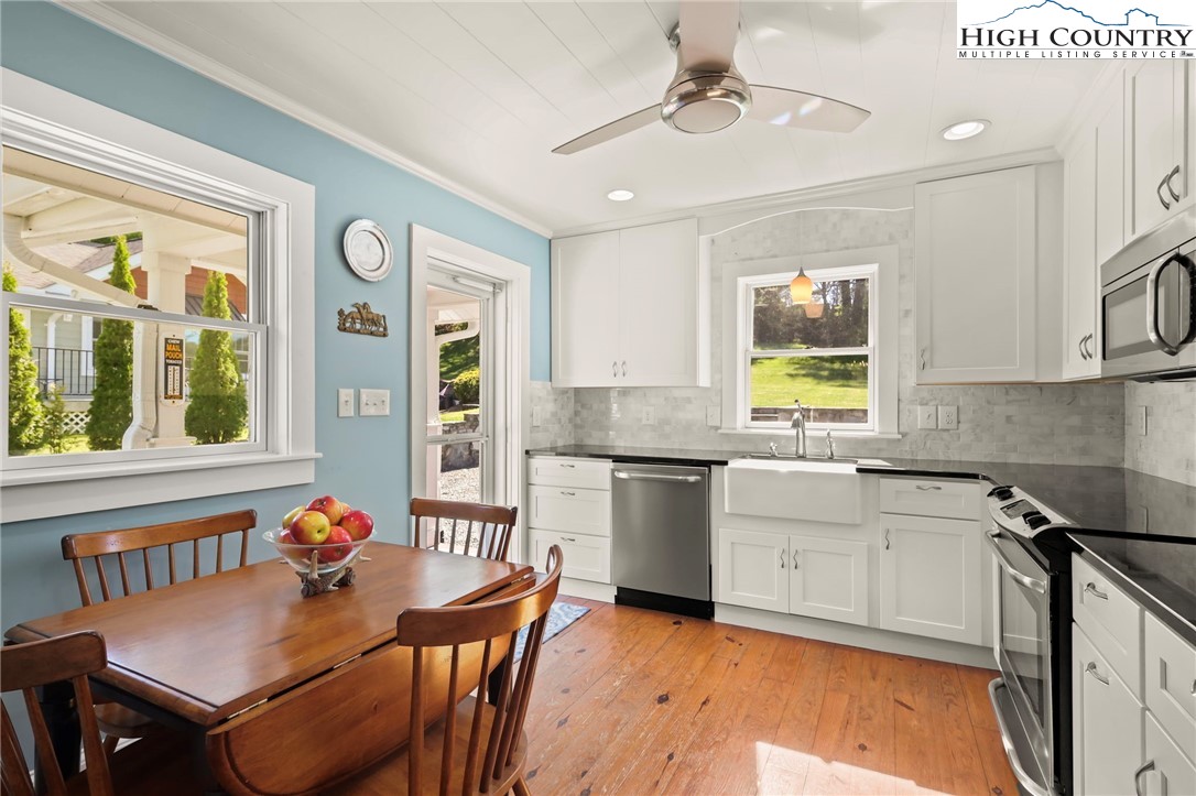 326 Ransom Street Blowing Rock, NC 28605 - Photo 9 of 25 a kitchen with granite countertop a stove a sink a dining table and chairs