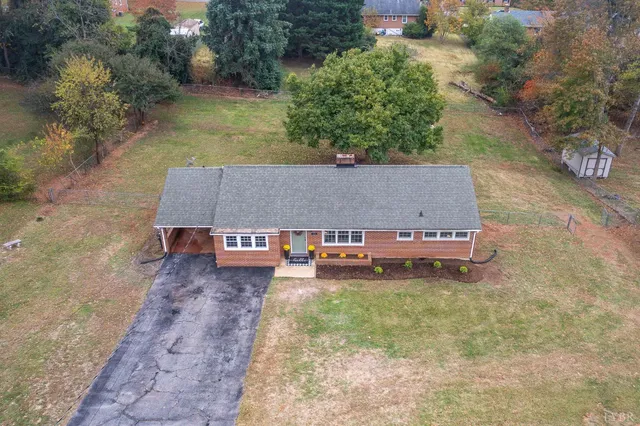 an aerial view of a house with a yard lake view and a large tree