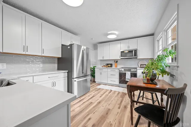 a kitchen with white cabinets stainless steel appliances and sink