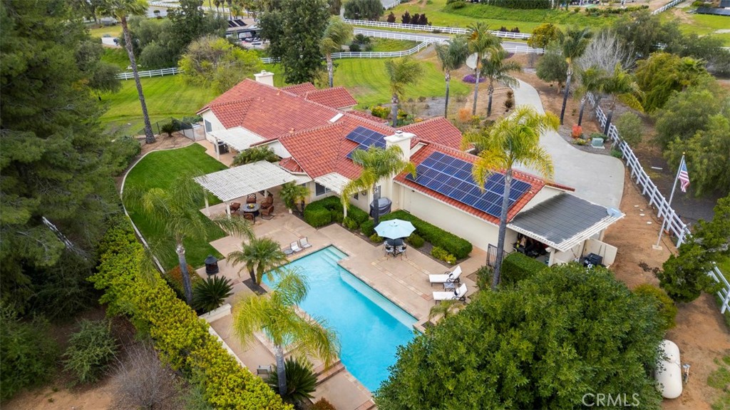 an aerial view of a house with a yard and outdoor seating