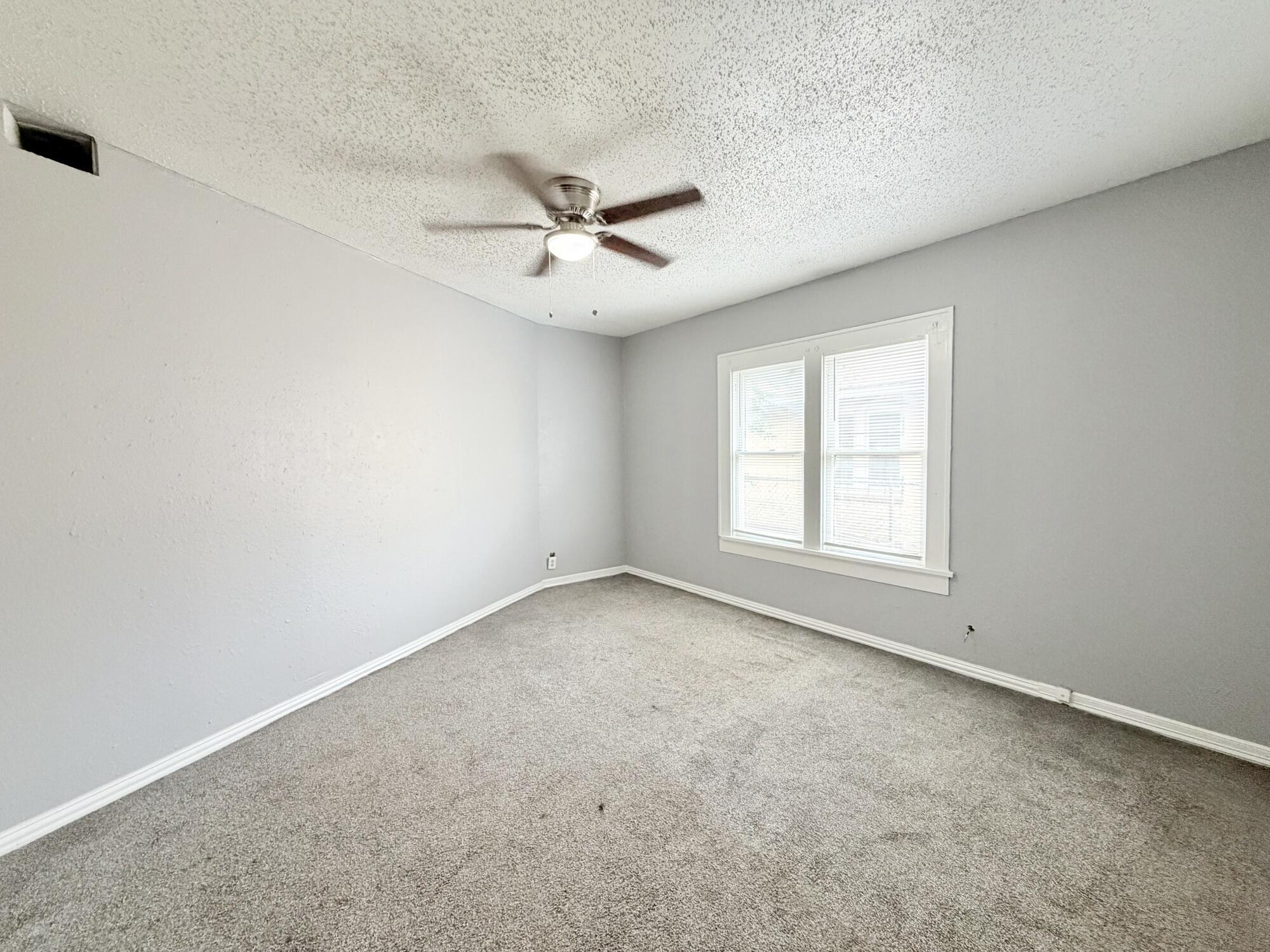 2119 15th Street Lubbock, TX 79401 - Photo 11 of 15 an empty room with a window and a fan