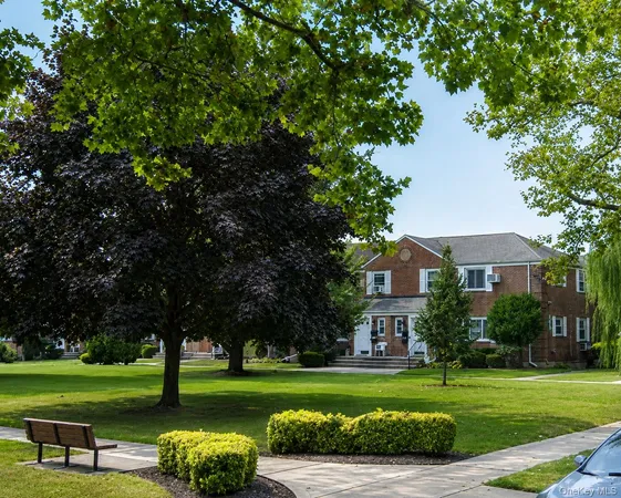 a view of a big house with a big yard and large trees