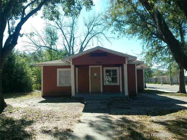 a front view of a house with a yard and trees